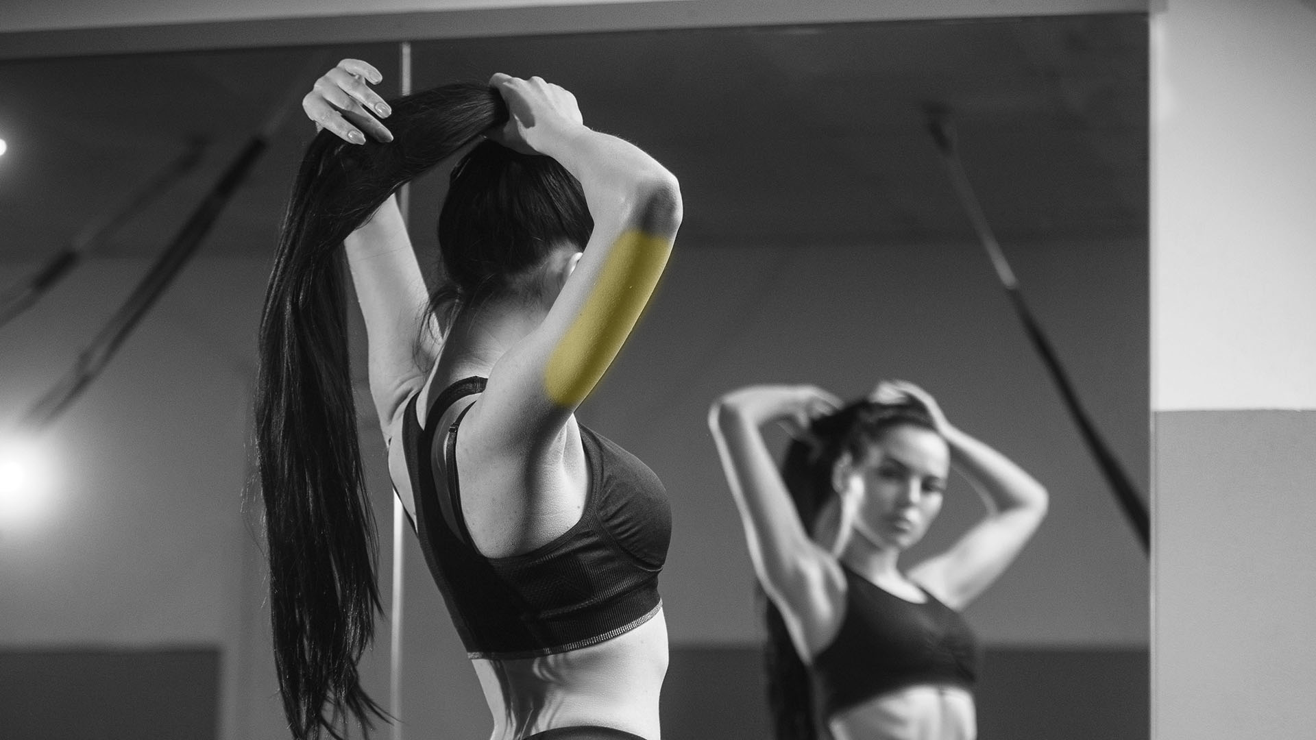 fit woman making stretching exercise in front of fitness studio mirror