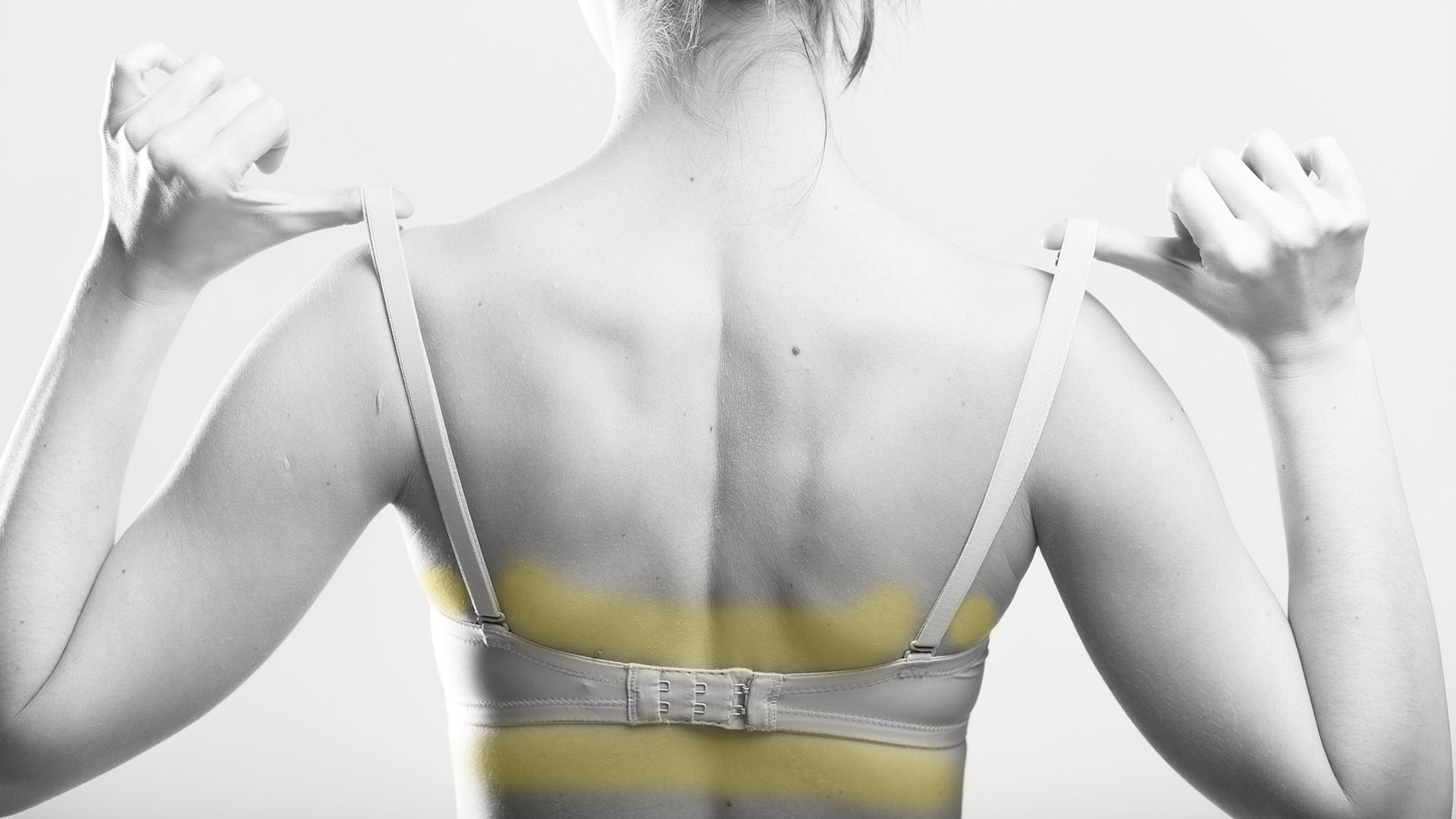 Woman holding a skin colored bra strap